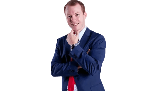 Smiling man in a blue suit and red tie posing confidently against a plain white background with arms crossed
