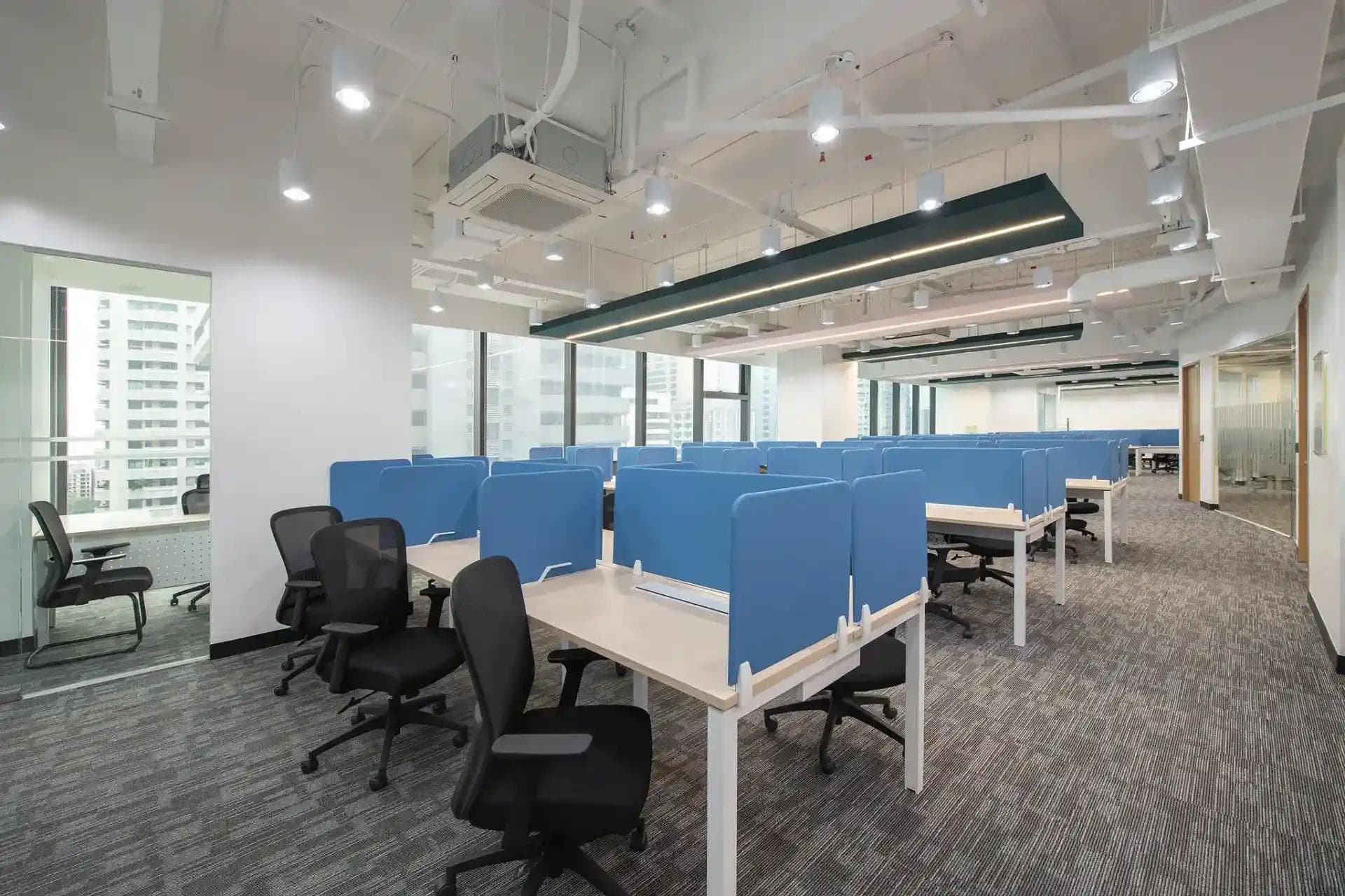 Modern Ortigas coworking space with rows of desks, blue partitions, ergonomic chairs, and bright lighting for a productive setup.