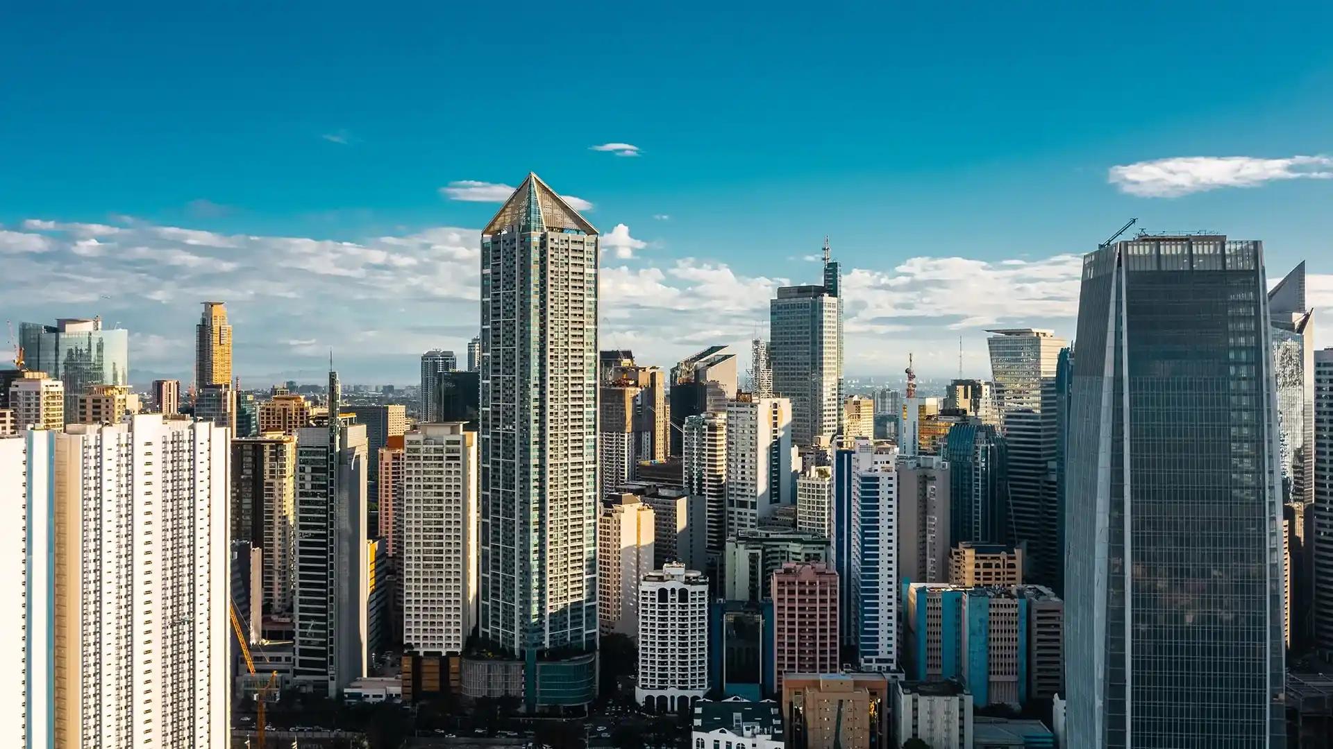 Skyscrapers dominate the skyline under a clear blue sky, showcasing Manila’s bustling and modern cityscape.