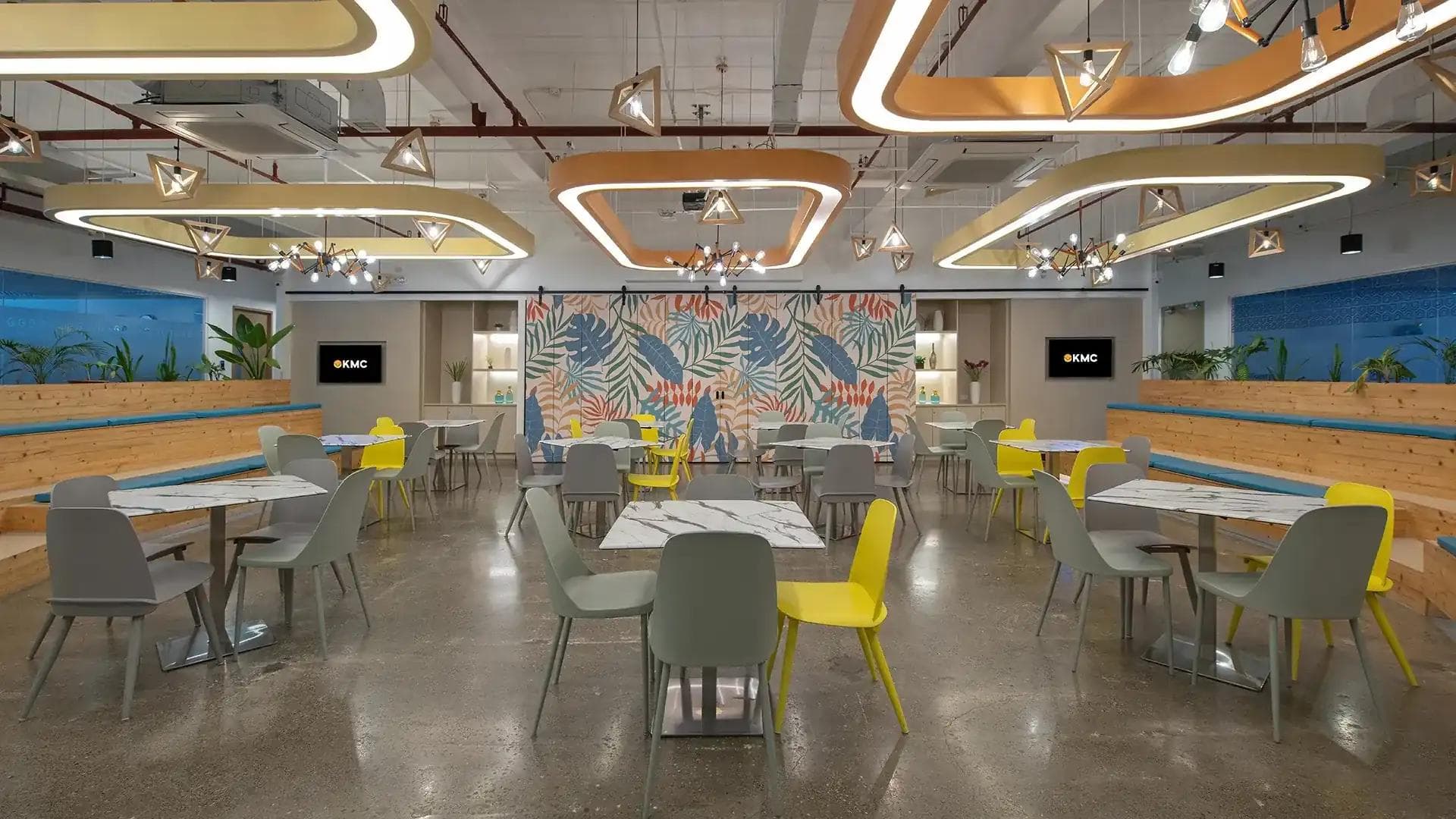 Colorful lounge area with modern lighting, vibrant mural, and mixed seating—part of KMC’s office amenities in Cebu.