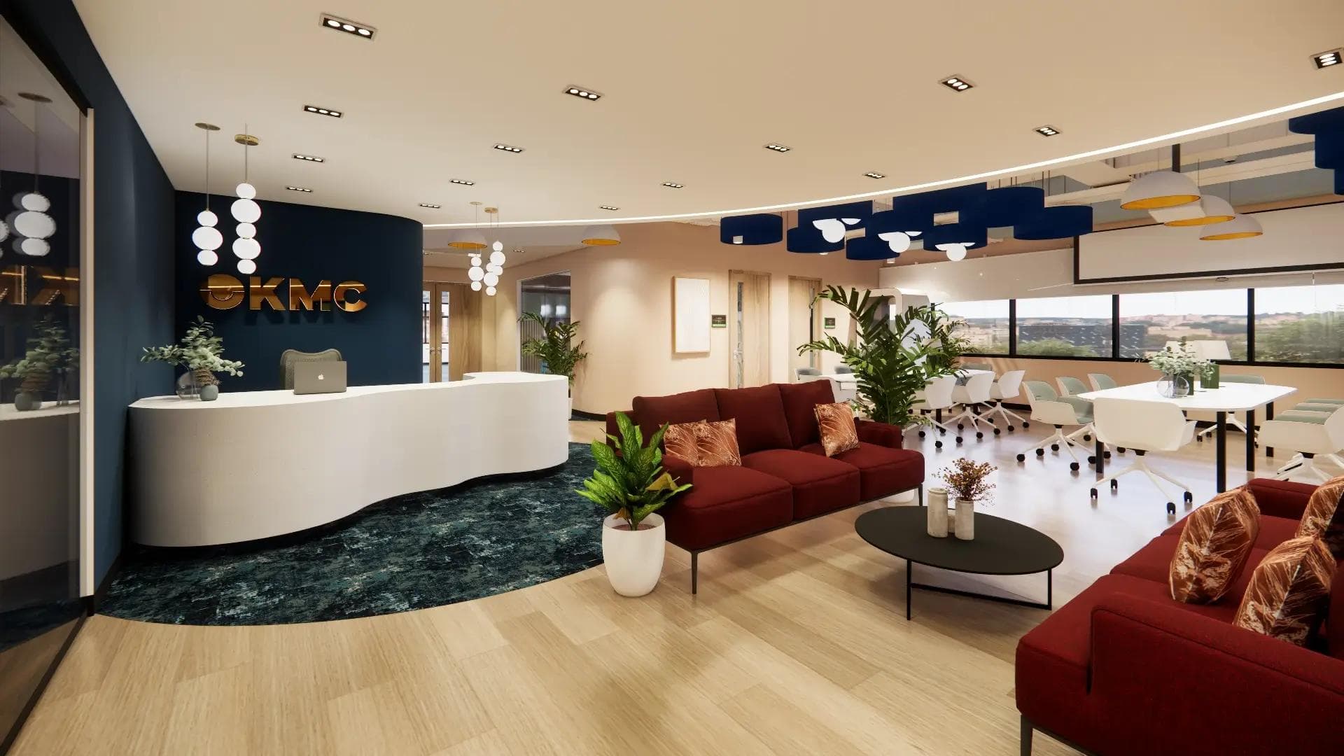 Modern KMC office lounge in Quezon City with red sofas, and a sleek white reception desk beside a glass-walled meeting room.