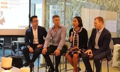 Four panelists, including one woman holding a microphone, engaged in a discussion during a KMC-hosted business event.