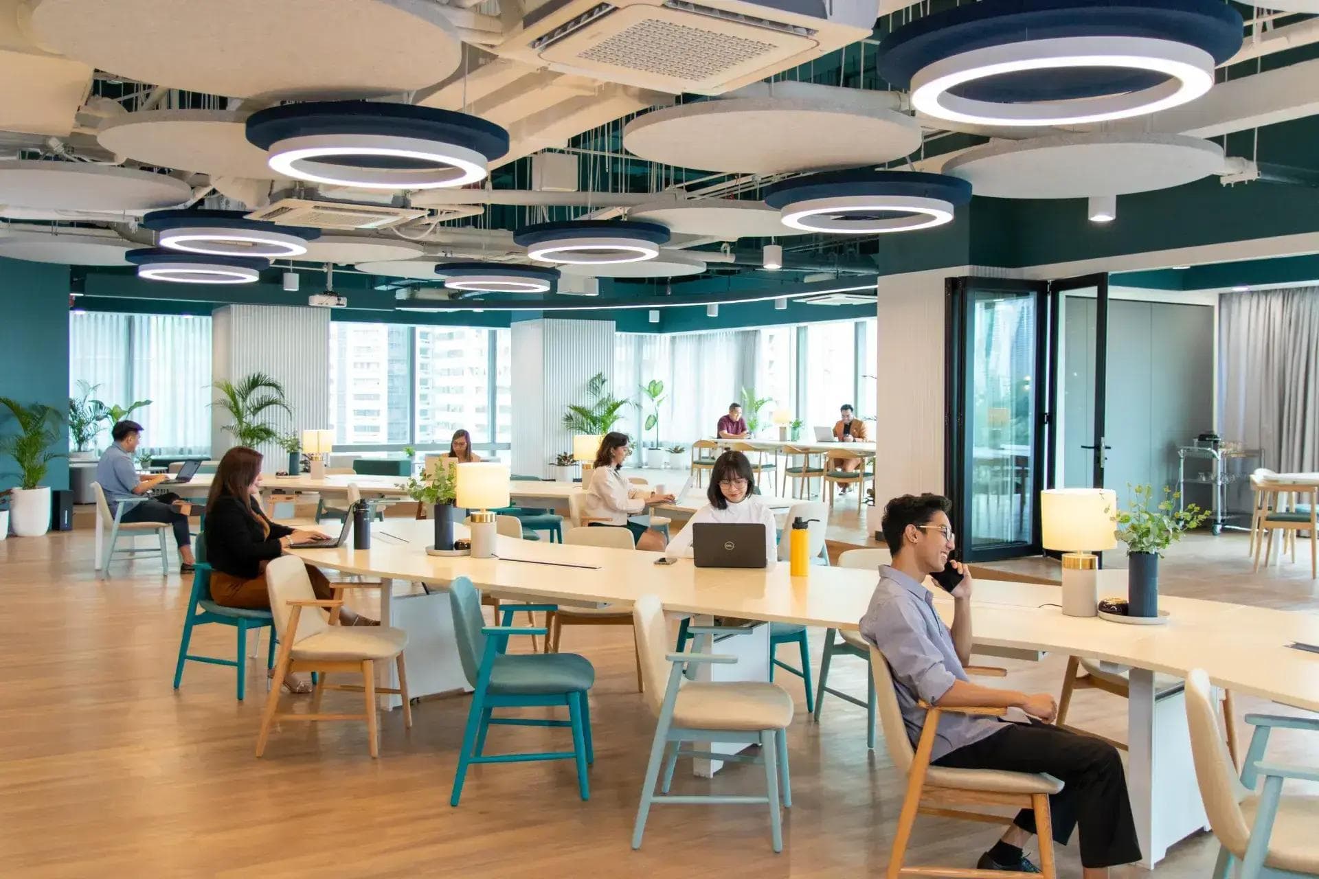 An office with 8 people, stylish chairs, and shared desks. Ideal for business leasing with open workspaces and natural light.